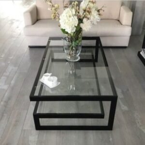 Mesa de centro con doble estructura metálica y tapa de cristal transparente. Diseño elegante, moderno y sofisticado para salones con estilo contemporáneo o industrial.